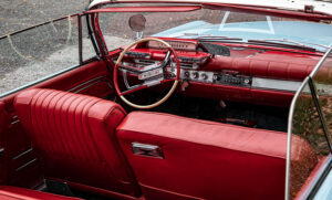 Interieur van een rode Dodge Polara cabriolet met vintage stuurwiel en dashboard uit de jaren 60
